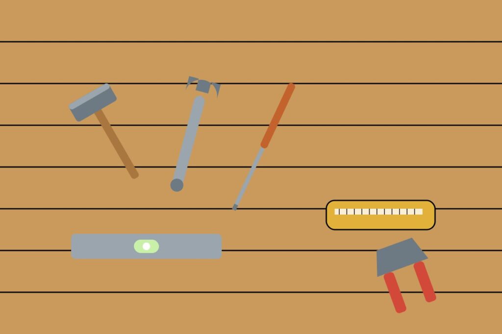 A set of basic hand tools laid out on a wooden surface